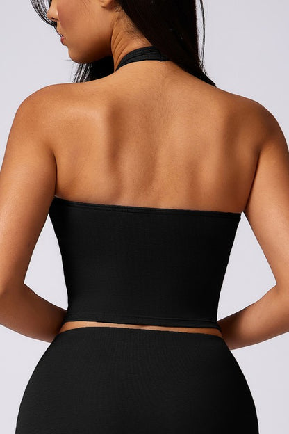 Black halter top worn by a person on a plain background