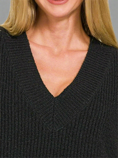Close-up of a person wearing a black sweater with a V-neck