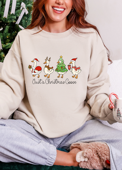Person wearing a cream sweatshirt with Christmas-themed design, sitting in front of a decorated Christmas tree.