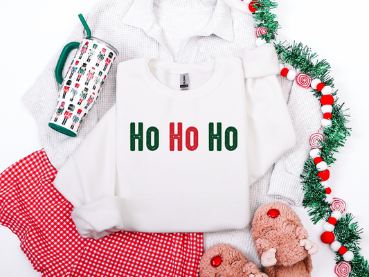 White sweatshirt with 'Ho Ho Ho' text, red mug, red pants, and festive decorations on a white background