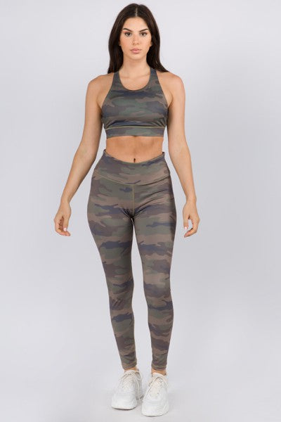 Woman wearing a camouflage sports bra and leggings set on a white background