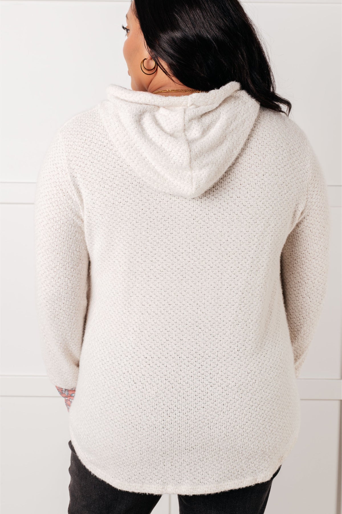 Person wearing a white textured hoodie with a hood against a light background