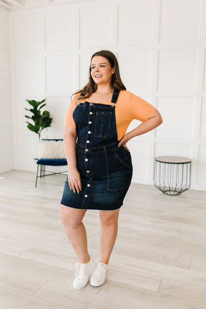 Woman wearing a denim dress with a white background