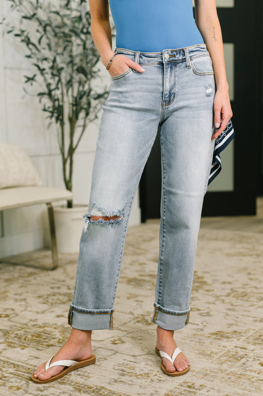 Person wearing light blue jeans with a slight distressed look, standing outdoors.