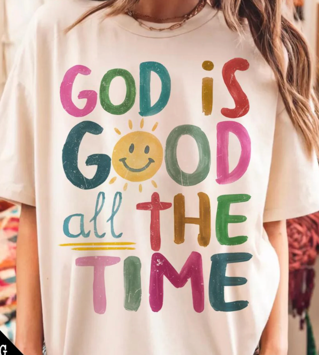 T-shirt with 'God is Good all the Time' text in colorful letters.