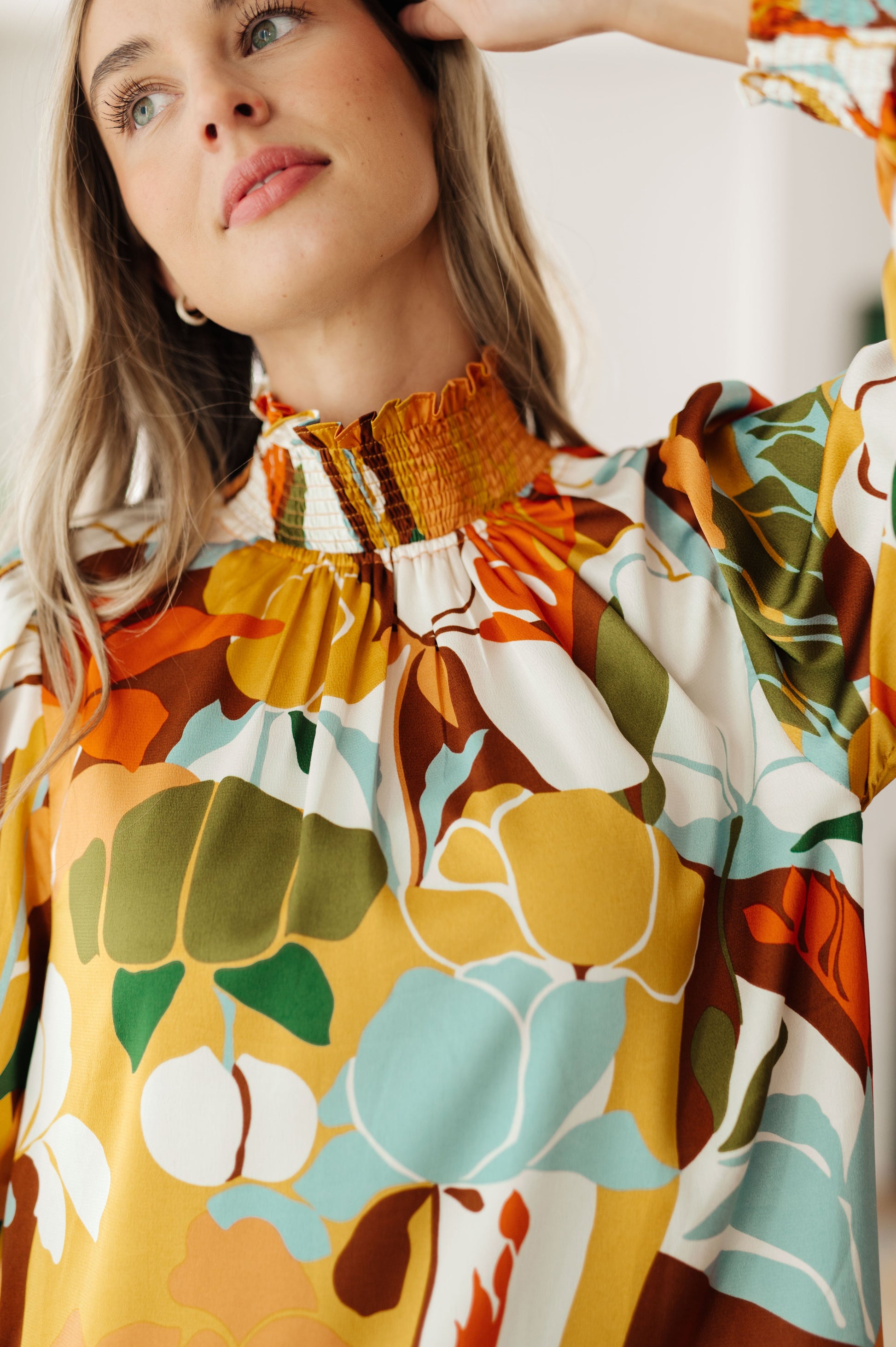 Woman wearing a colorful floral dress with a close-up of the neckline.