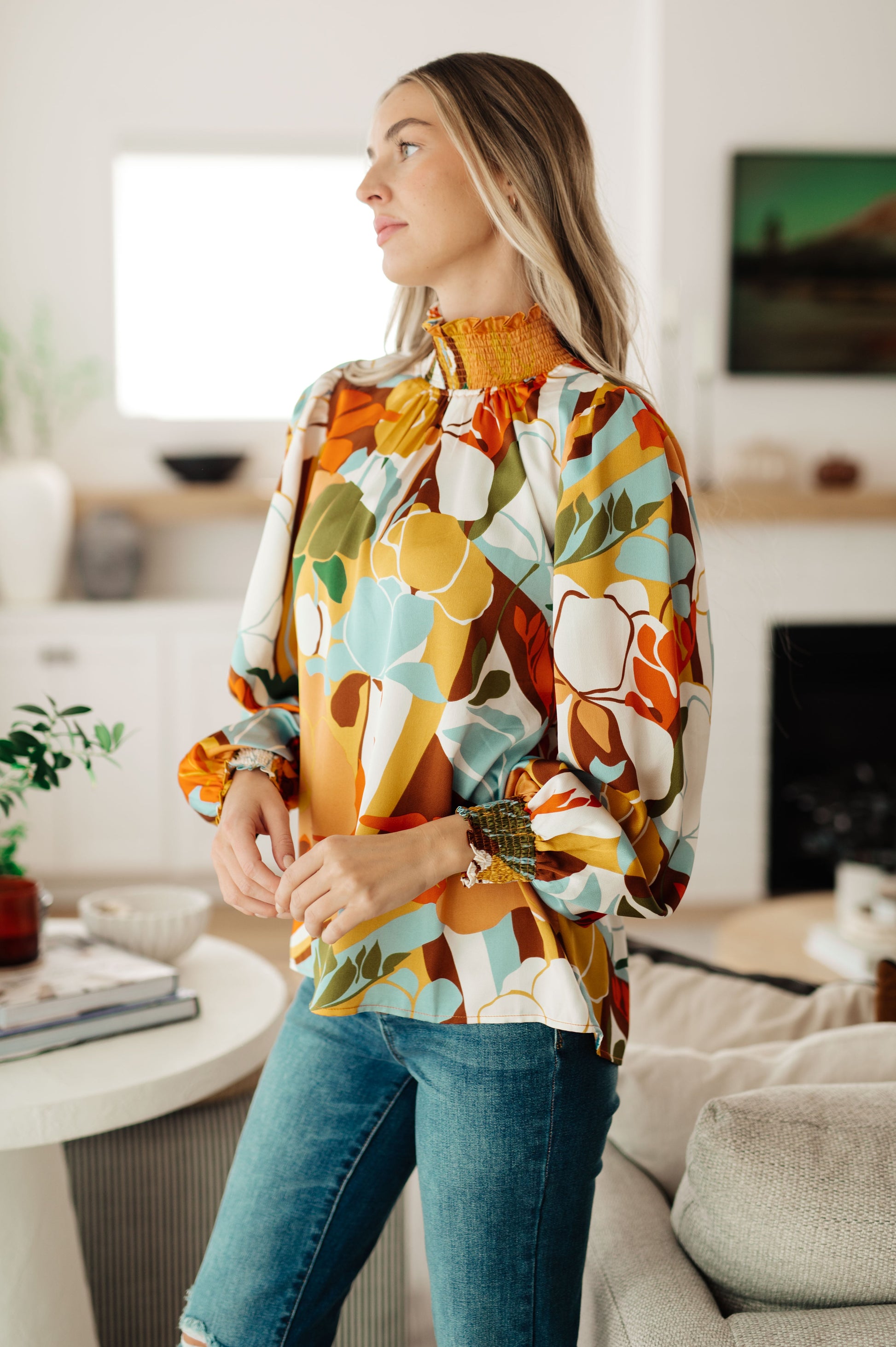 Woman wearing a colorful floral jacket in a living room setting