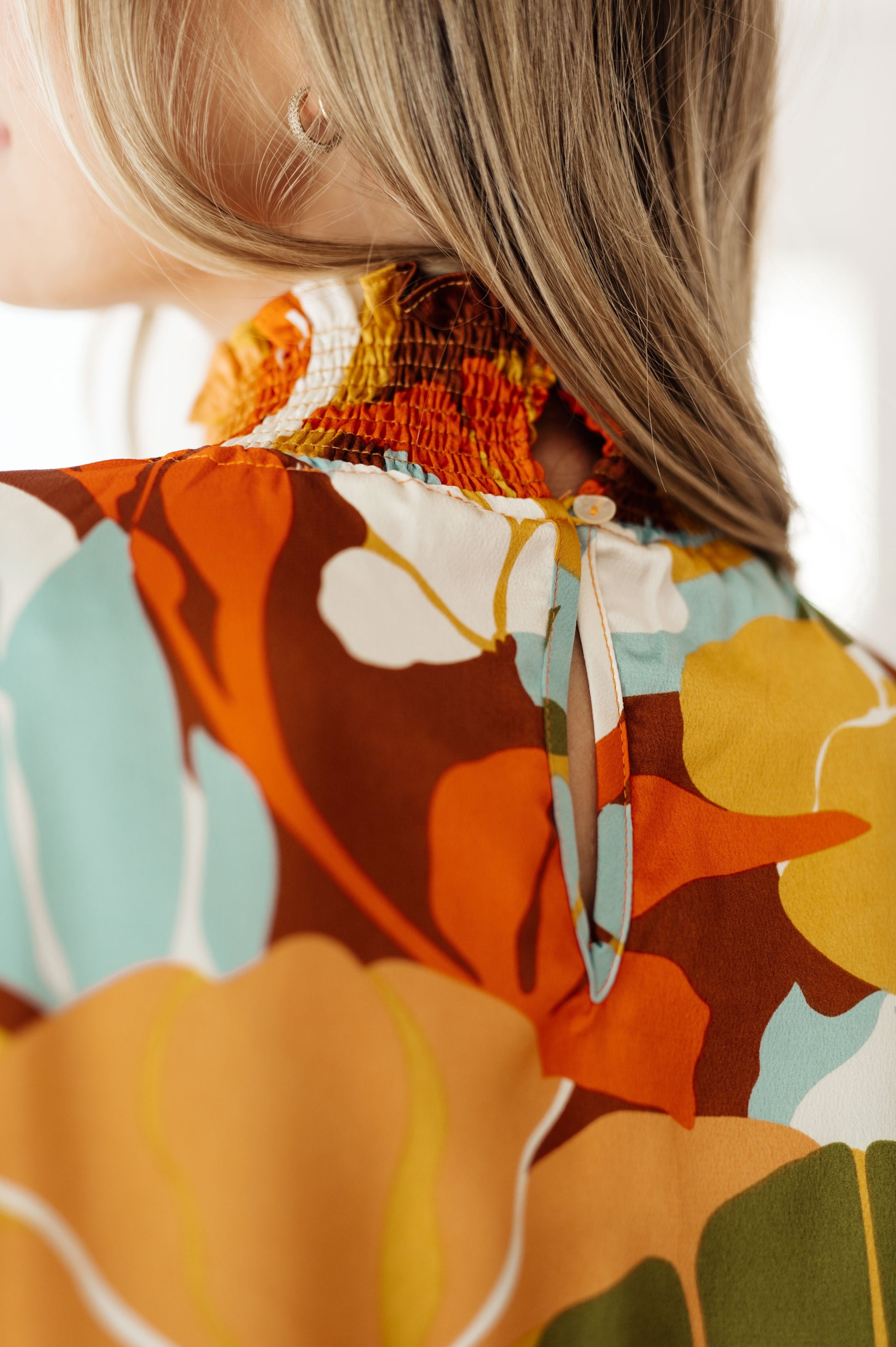 Close-up of a person wearing a colorful floral dress with a blurred background