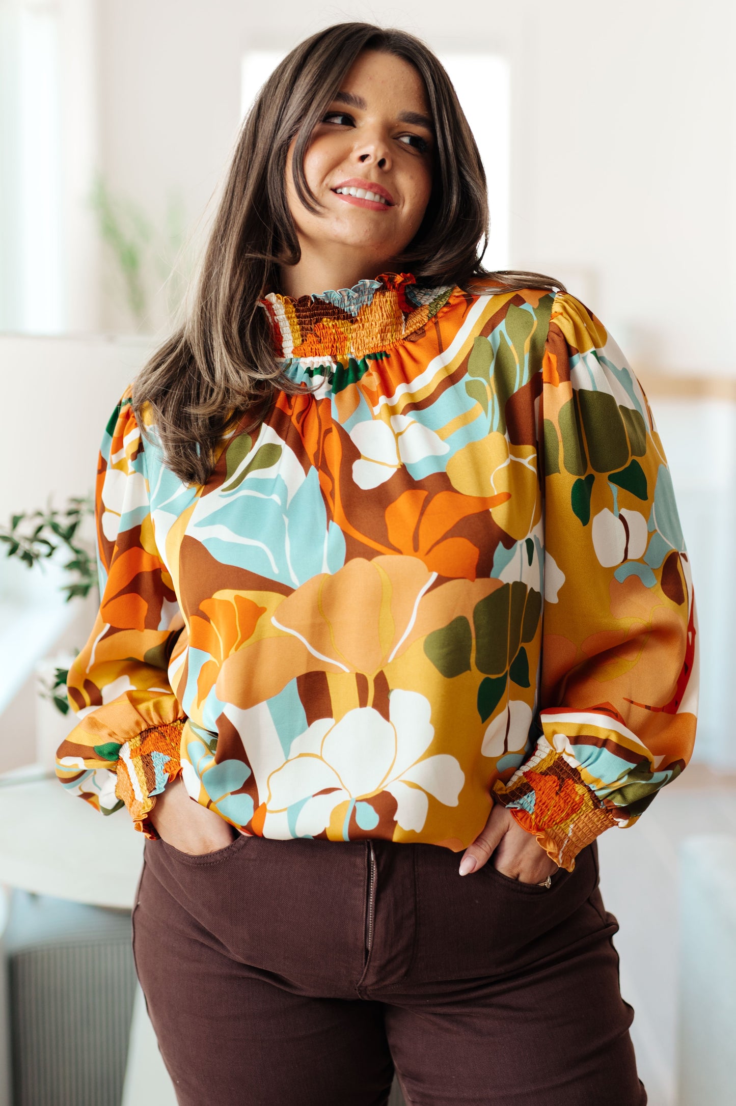 Woman wearing a colorful floral sweatshirt indoors