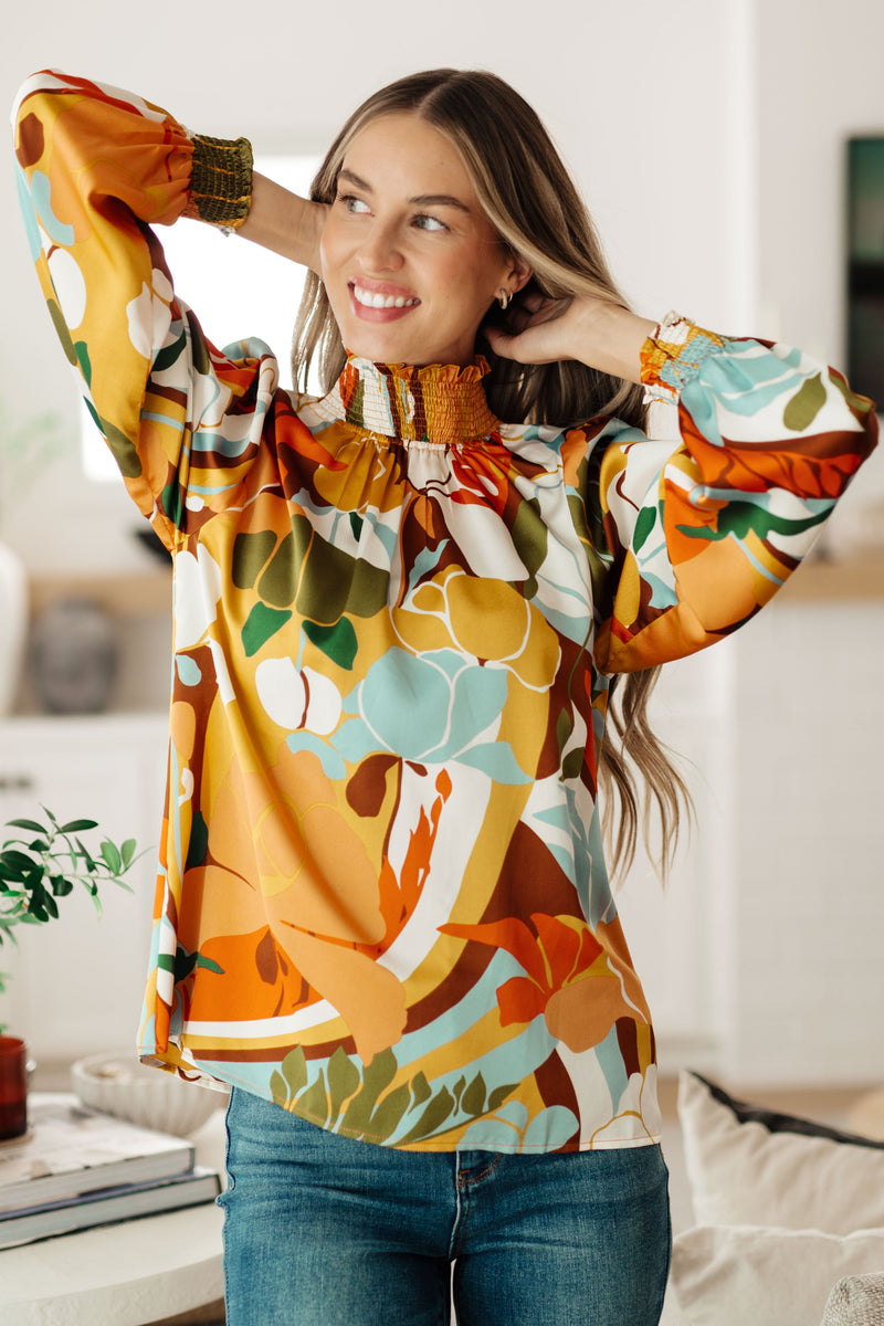 Woman wearing a colorful floral blouse in a home setting