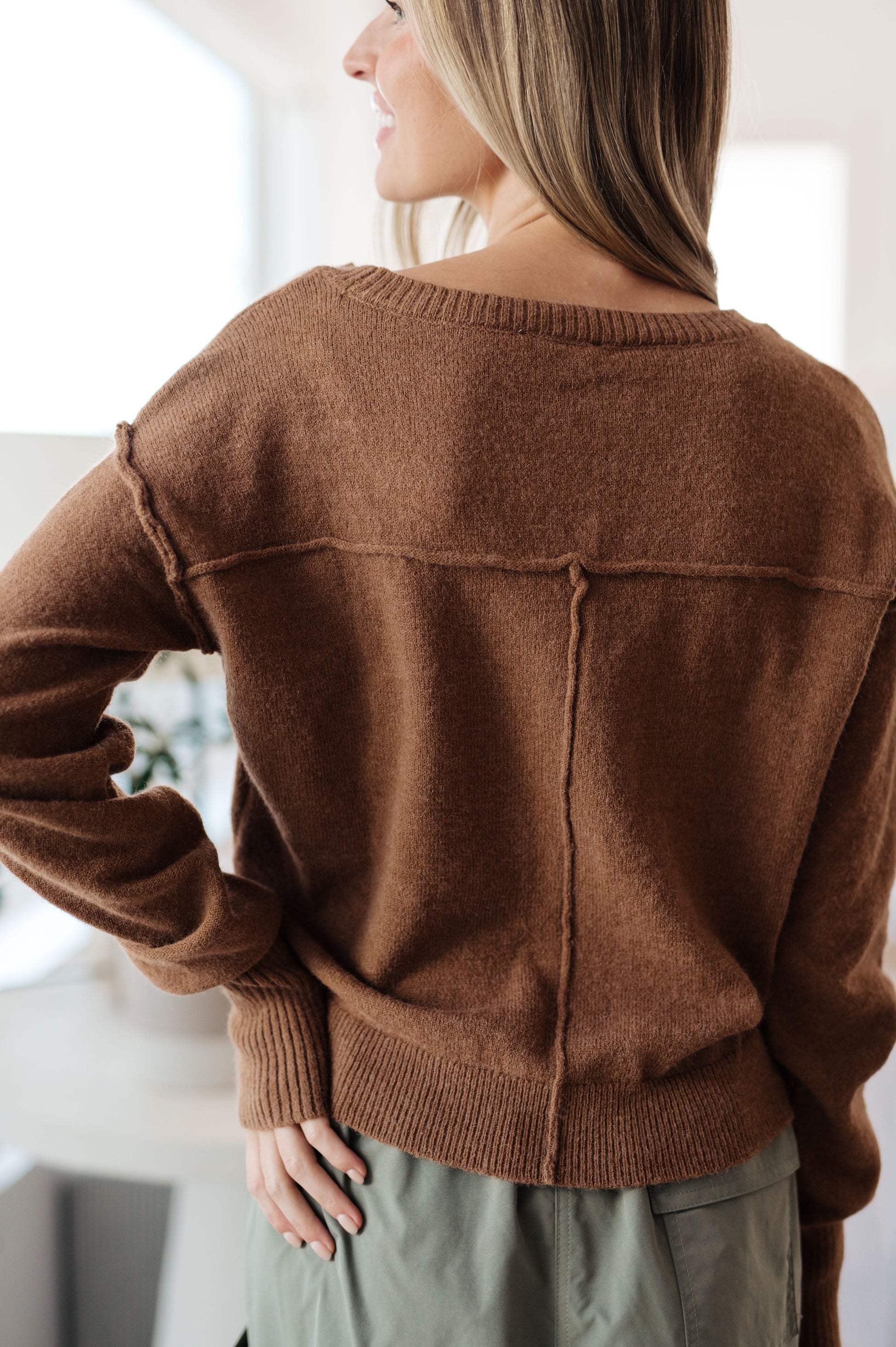 Person wearing a brown sweater in an indoor setting