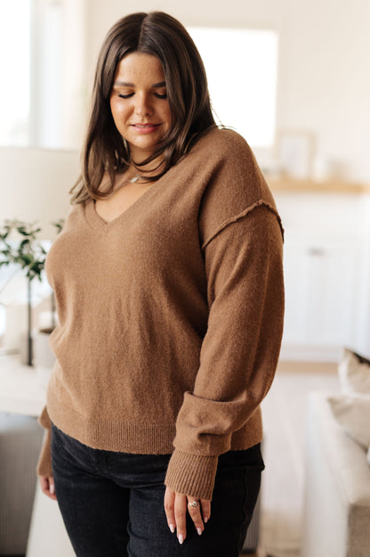 Woman wearing a brown sweater in a bright room
