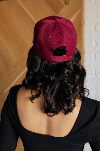Person wearing a red cap from behind with a wooden door and white wall in the background