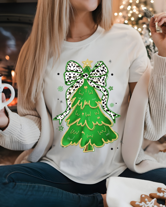 Person wearing a sweater with a Christmas tree design, holding a mug in a cozy indoor setting.