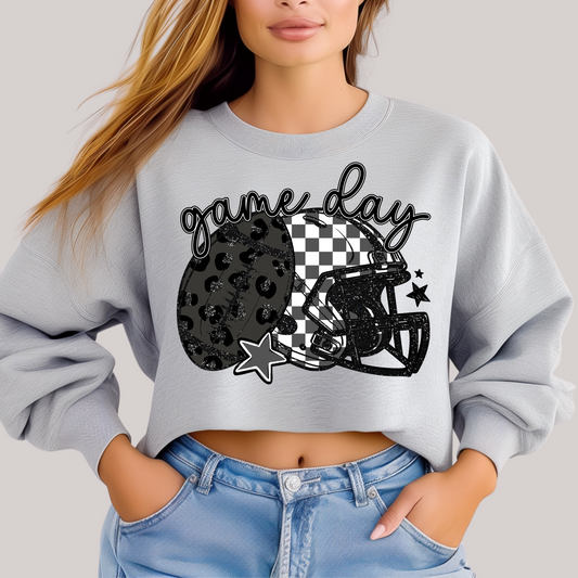 Person wearing a gray sweatshirt with a 'game day' design featuring a leopard print helmet and checkered pattern.