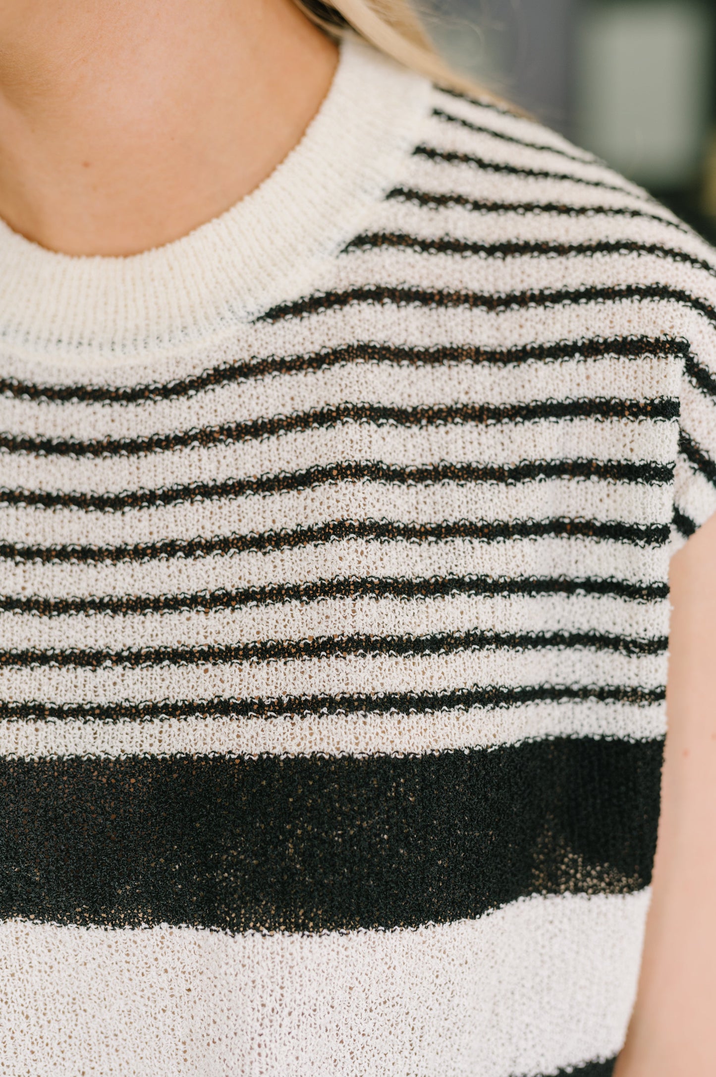 Close-up of a person wearing a black and white striped sweater.