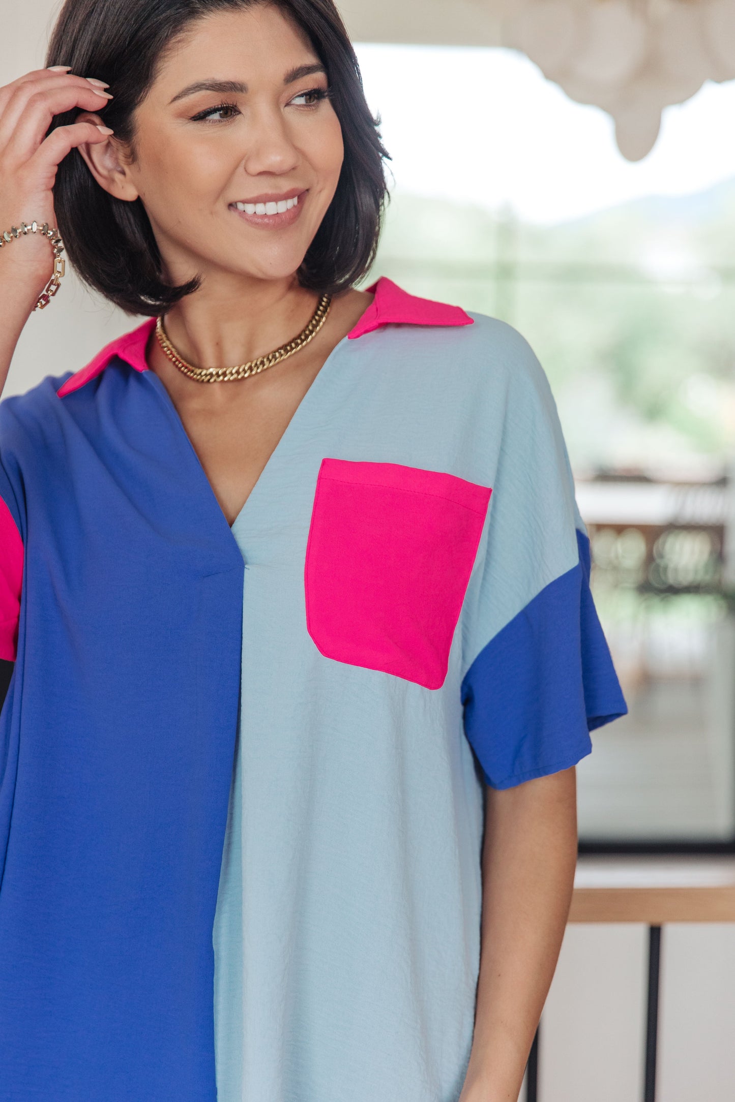 Woman wearing a colorful top with a blurred background