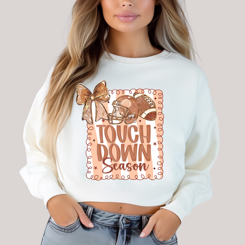 Person wearing a white sweatshirt with 'Tough Down Season' design