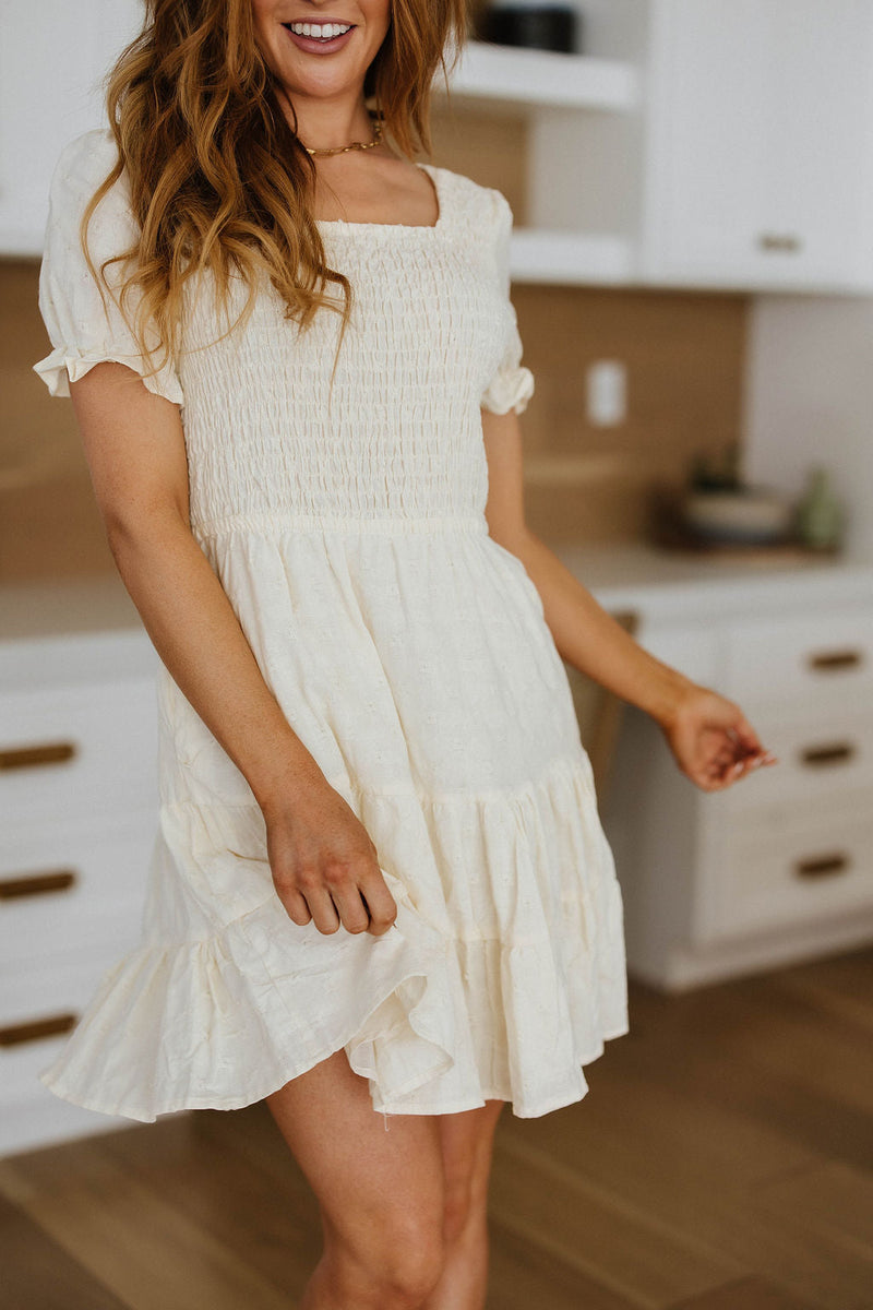 Woman wearing a white dress in a kitchen setting