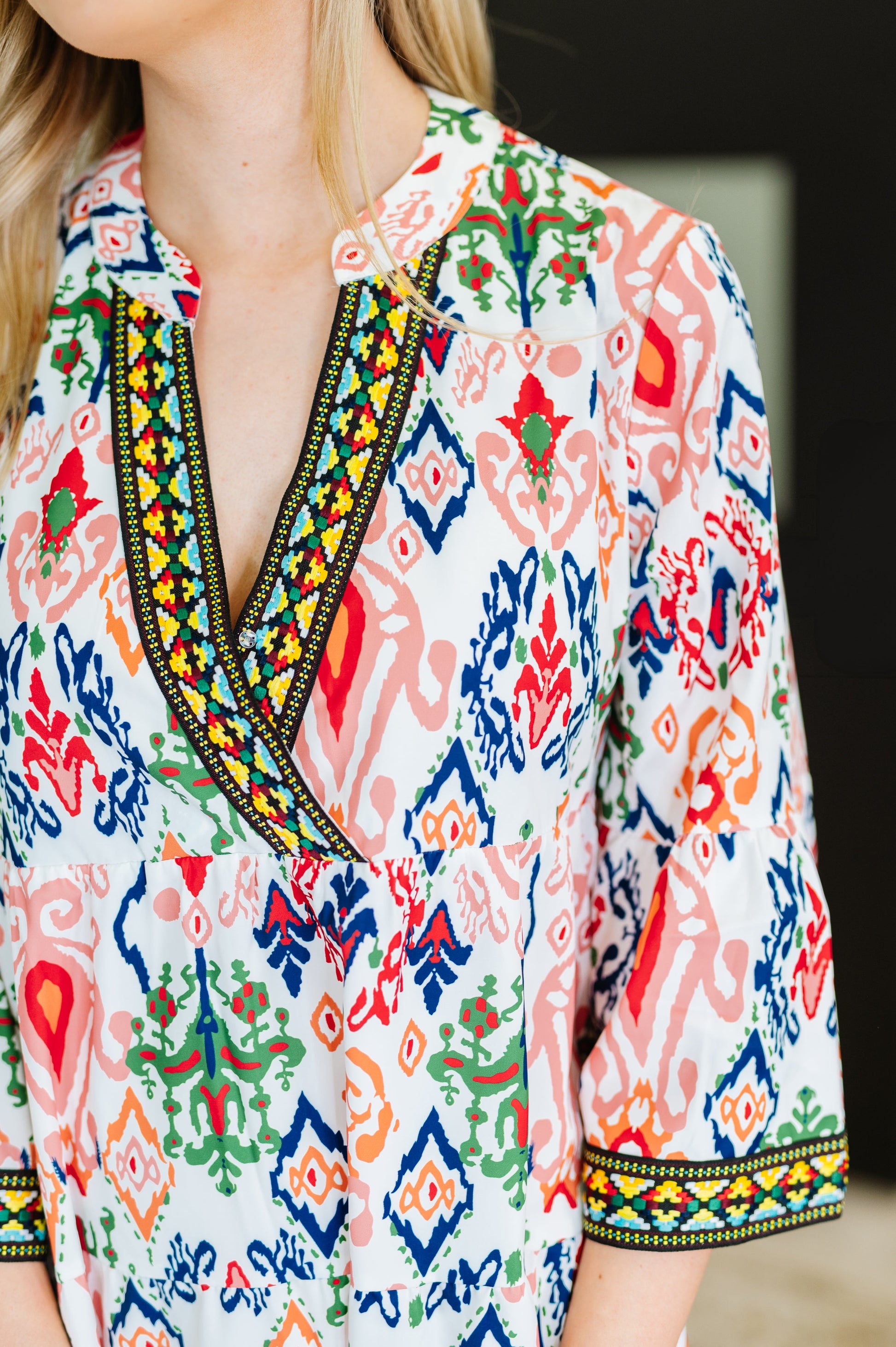 Colorful patterned dress with a deep neckline and embroidered details.