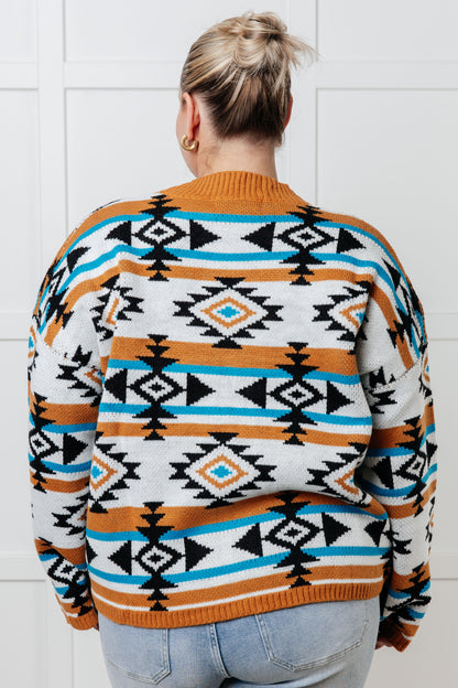 Person wearing a patterned sweater with a white tiled wall background