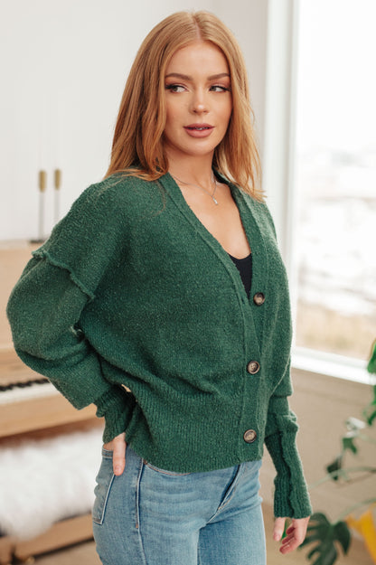 Woman wearing a green cardigan with a blurred indoor background
