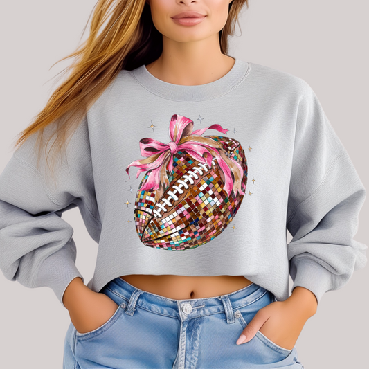 Person wearing a light gray sweatshirt with a colorful sequin pineapple design on a plain background