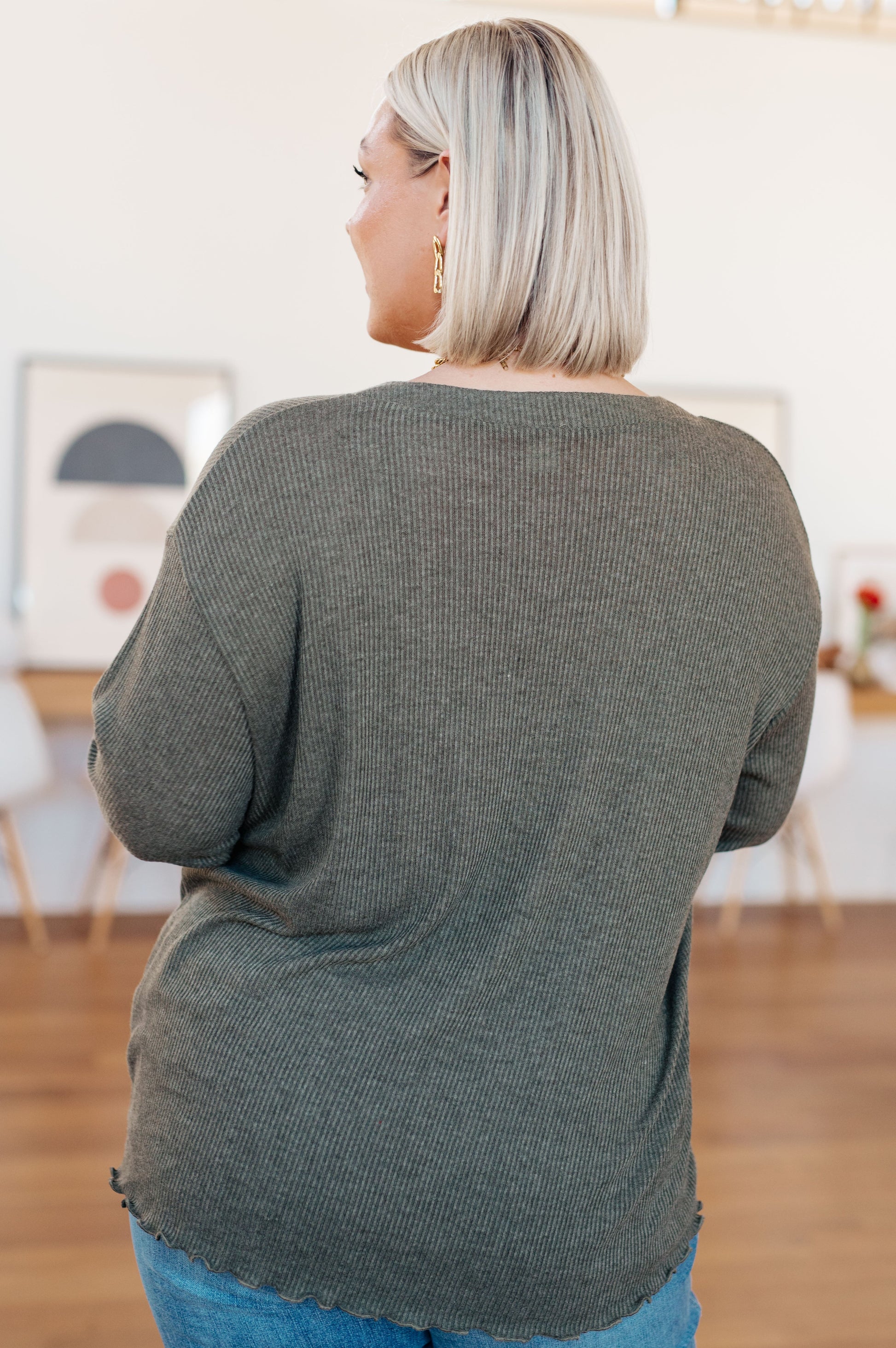 Person wearing a green sweater in an indoor setting