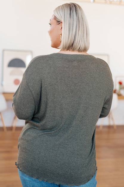 Person wearing a green sweater in an indoor setting
