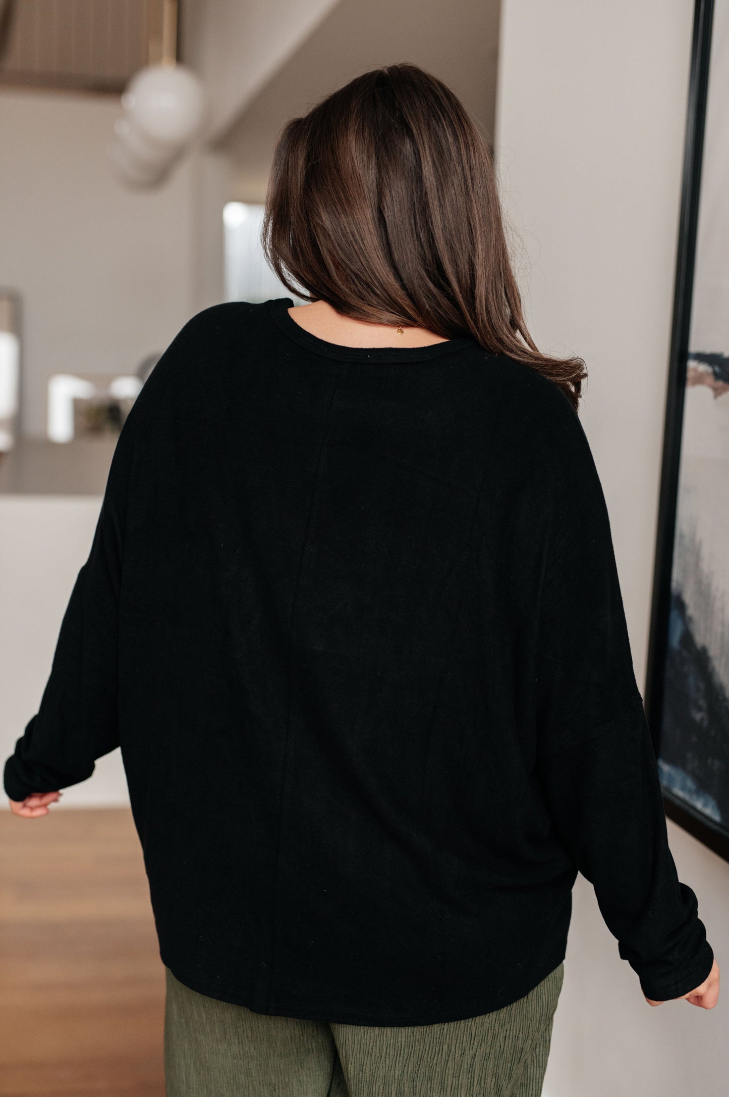 Person wearing a black sweater in an indoor setting