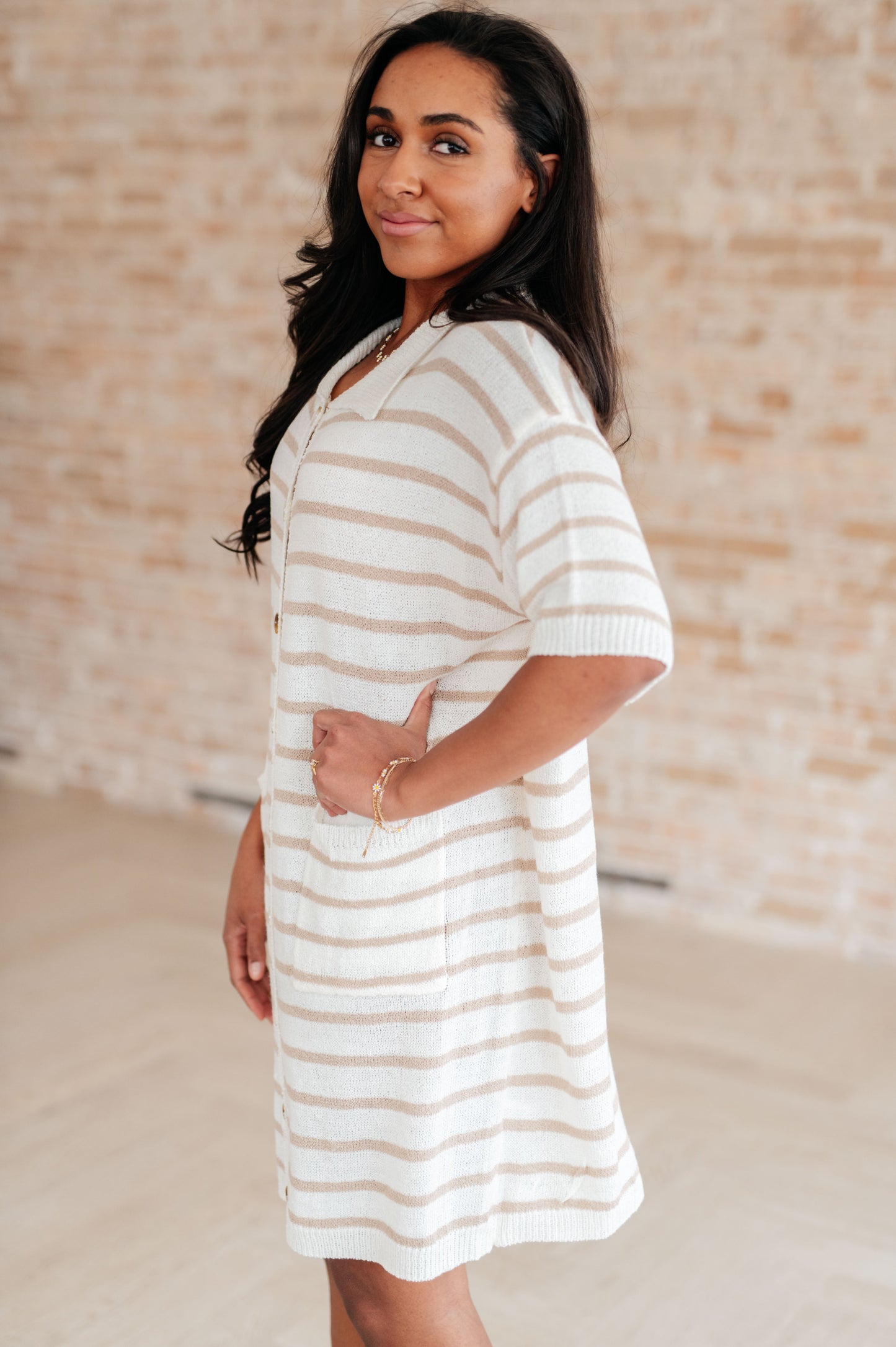 Woman wearing a striped dress against a neutral background