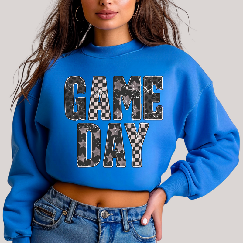 Blue sweatshirt with 'GAME DAY' text worn by a person on a plain background