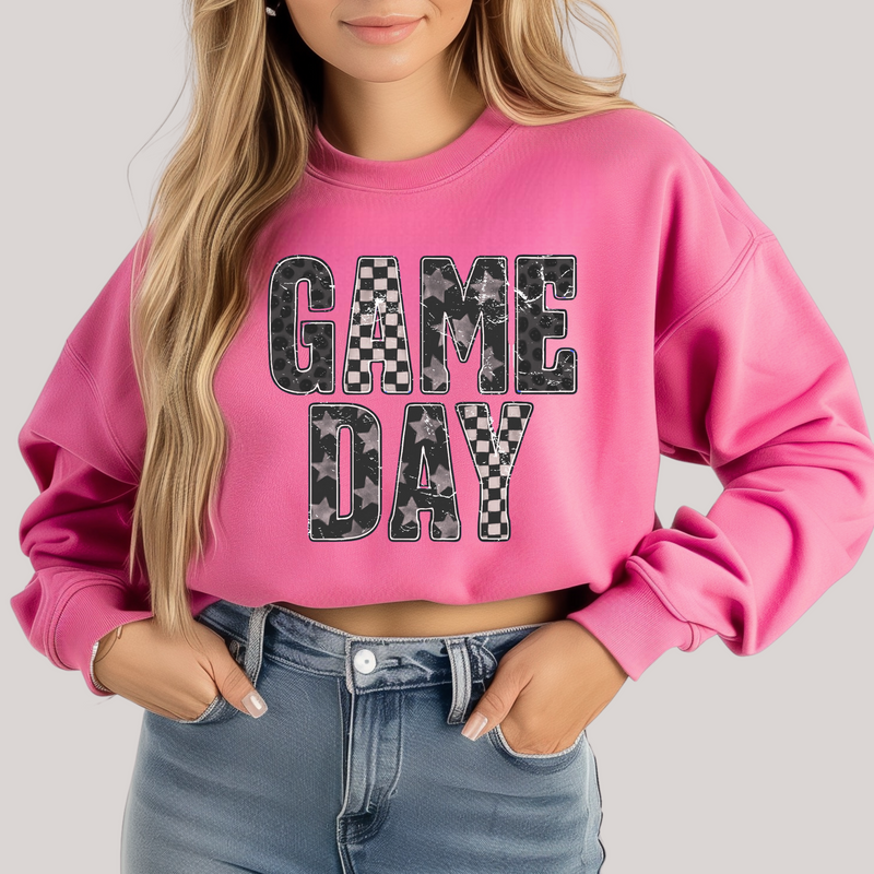 Person wearing a pink sweatshirt with 'GAME DAY' text on a plain background
