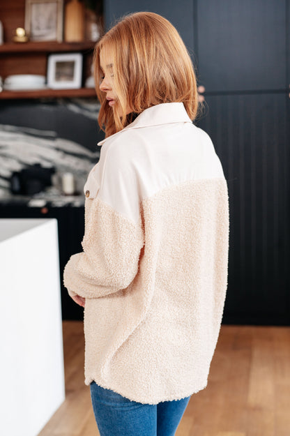 Woman wearing a beige fleece jacket in a kitchen setting