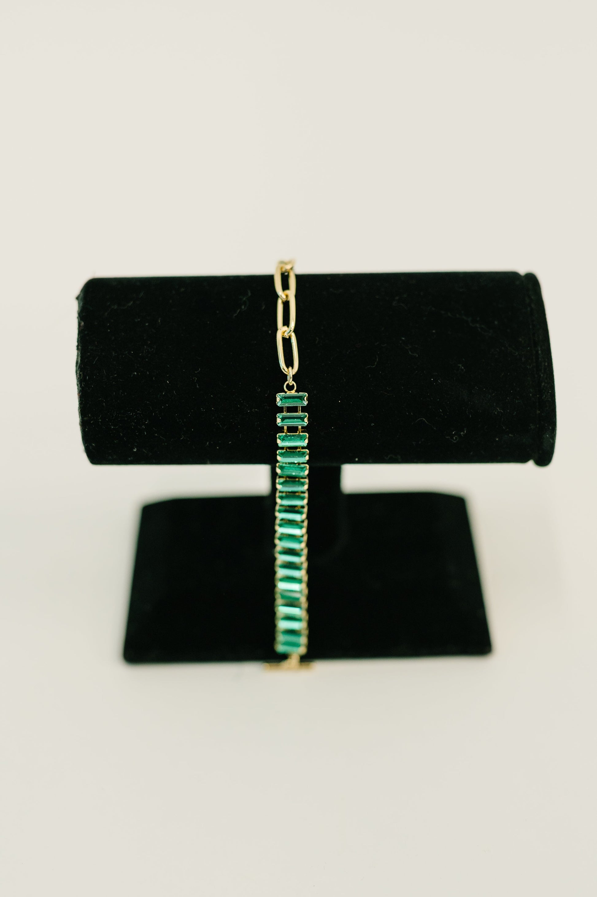 Turquoise bracelet on a black velvet stand with a white background