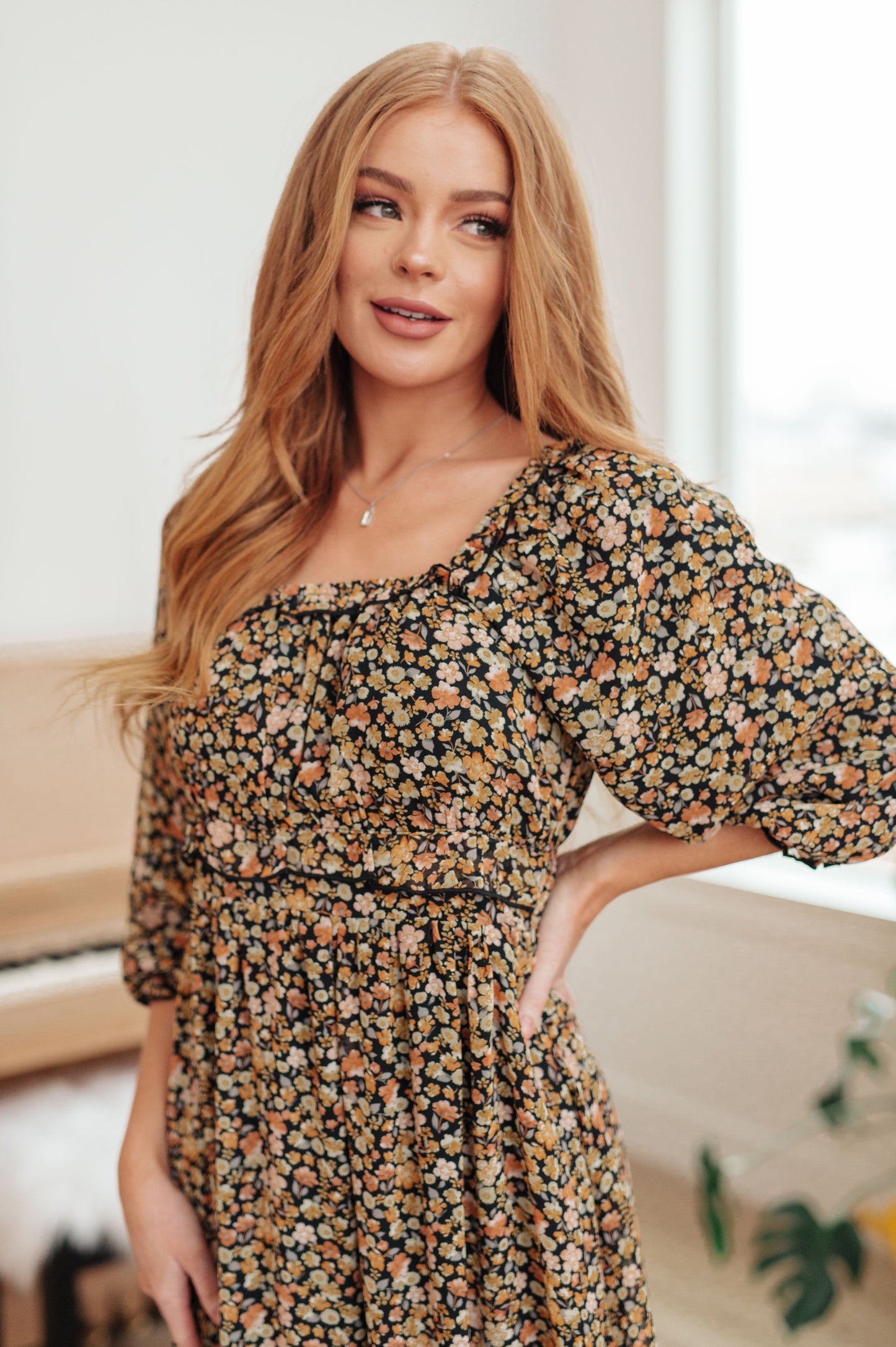 Woman wearing a floral dress in an indoor setting