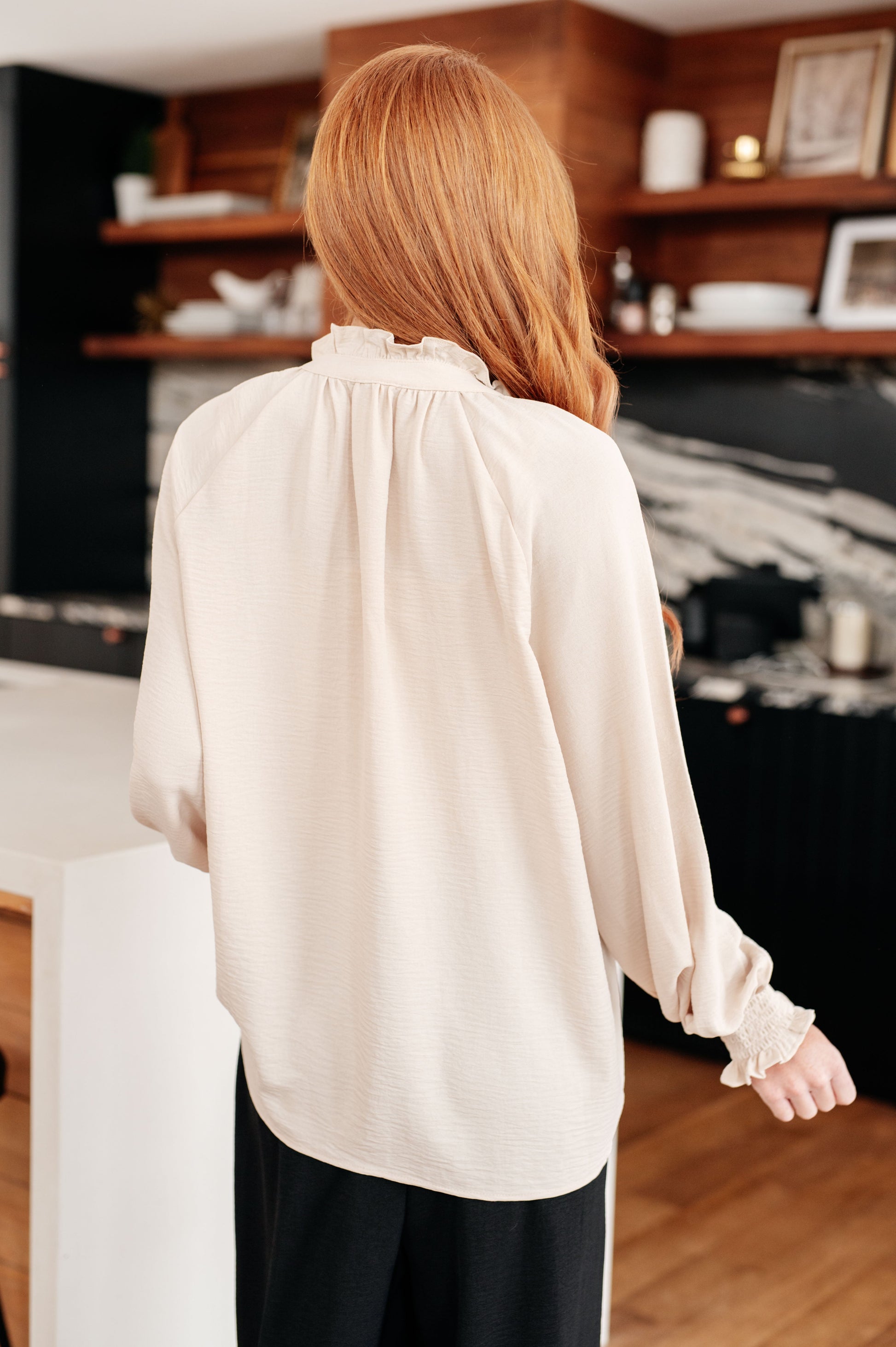 Woman wearing a beige blouse in a kitchen setting