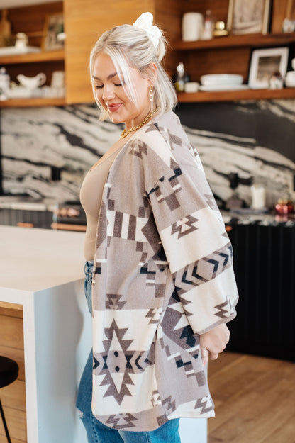Woman wearing a patterned cardigan in a kitchen setting