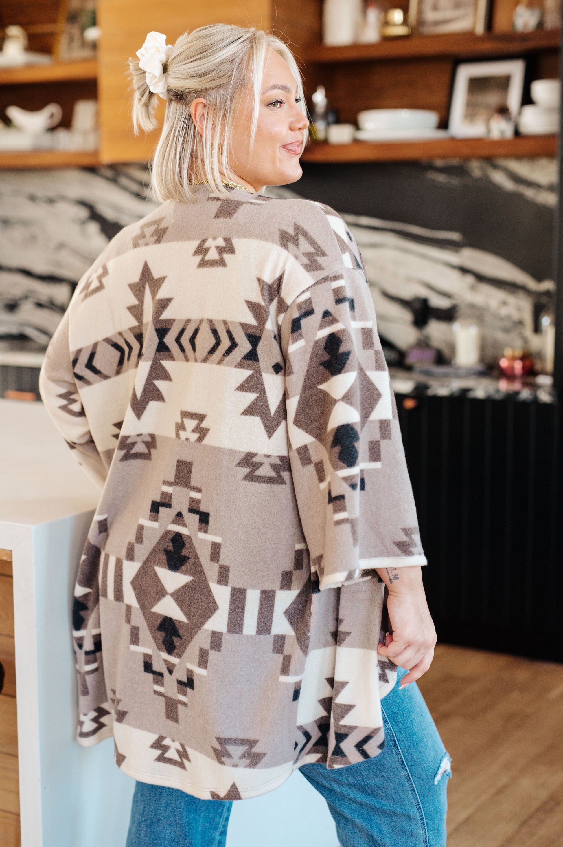 Woman wearing a patterned cardigan in a kitchen setting