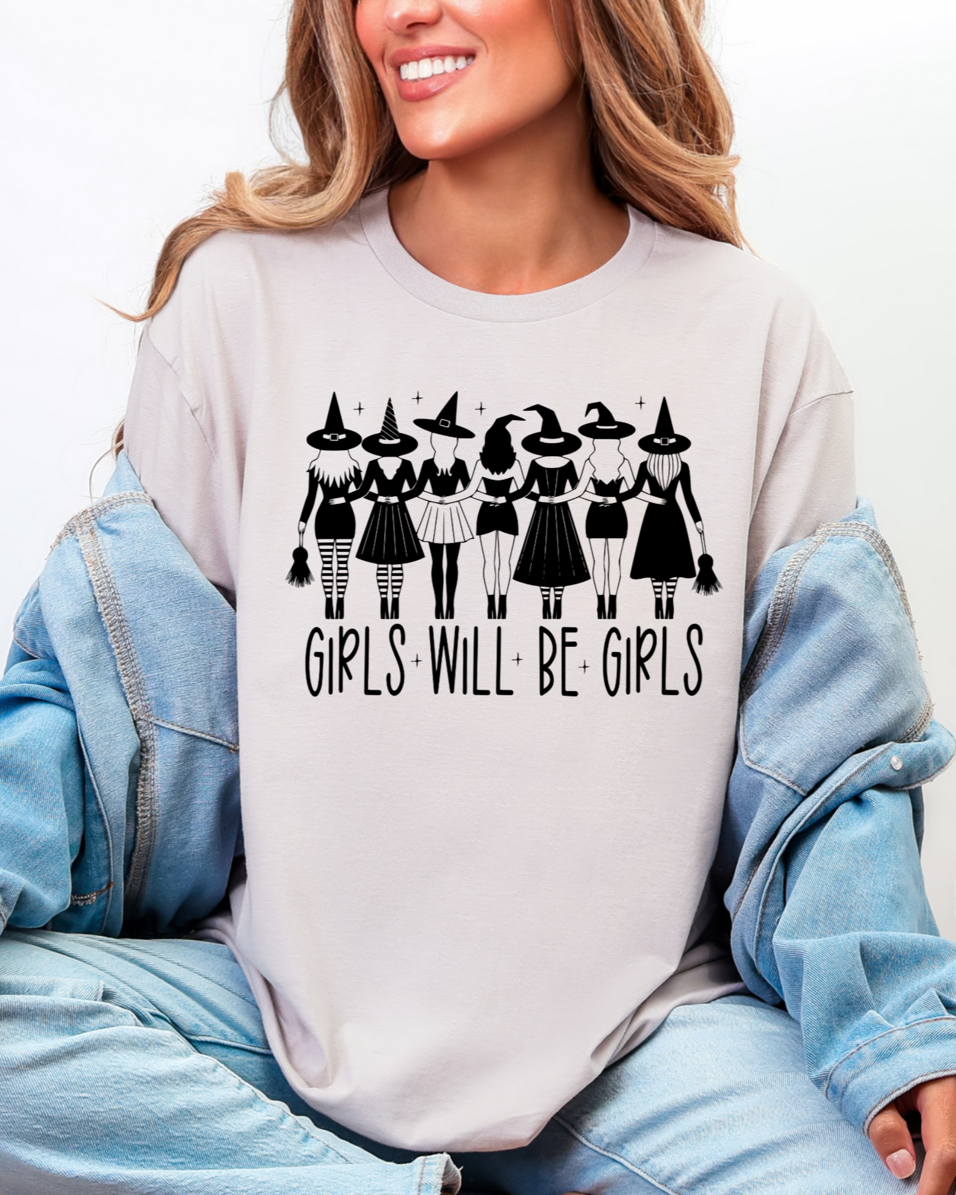 Person wearing a white sweatshirt with a graphic design and text, sitting on a white background.