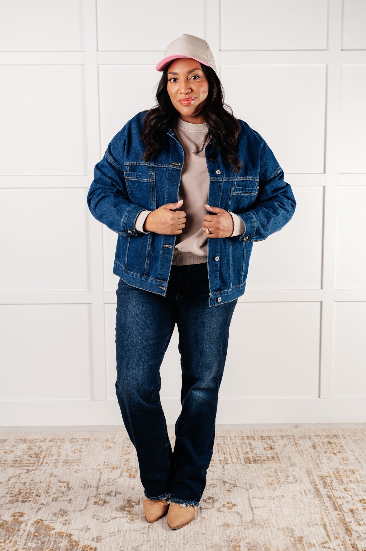 Person wearing a denim jacket and jeans with a white background