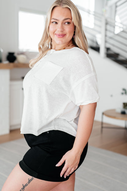 Woman wearing a white top and black shorts in a modern indoor setting