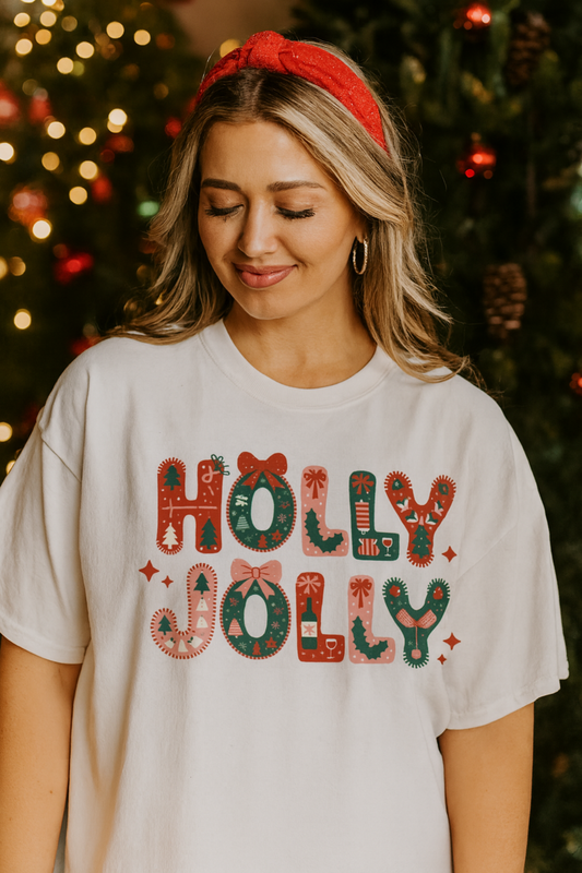 Woman wearing a 'Holly Jolly' shirt in front of a decorated Christmas tree.