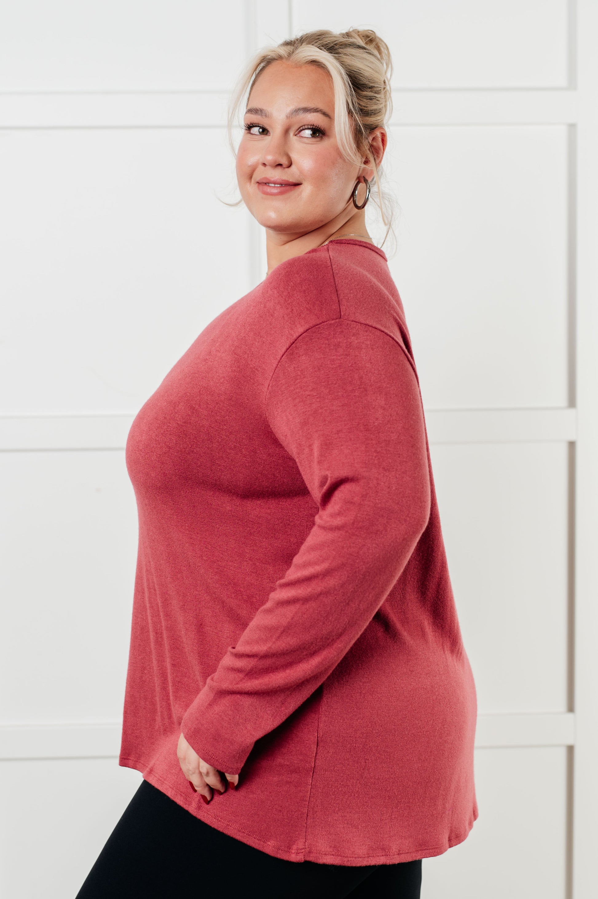 Woman wearing a red sweater against a white background