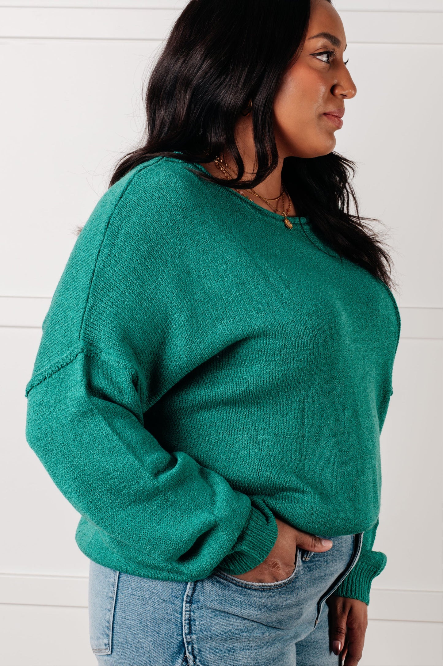 Person wearing a green sweater against a white background