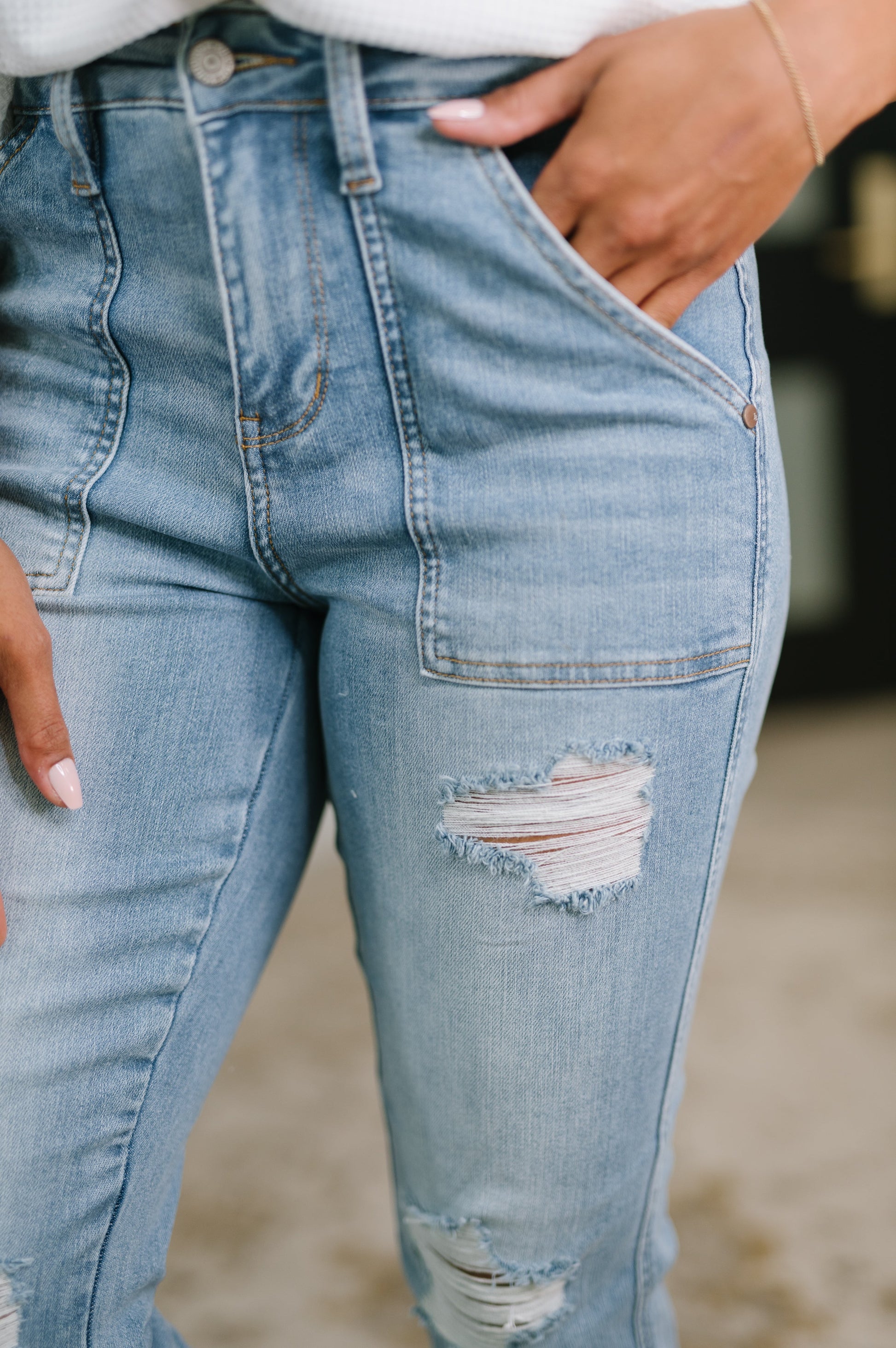 Close-up of light blue jeans with a tear on a blurred background