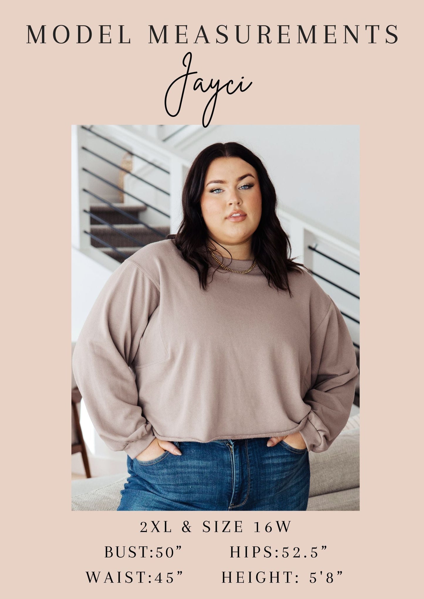 Woman wearing a beige sweater and blue jeans with model measurements displayed.