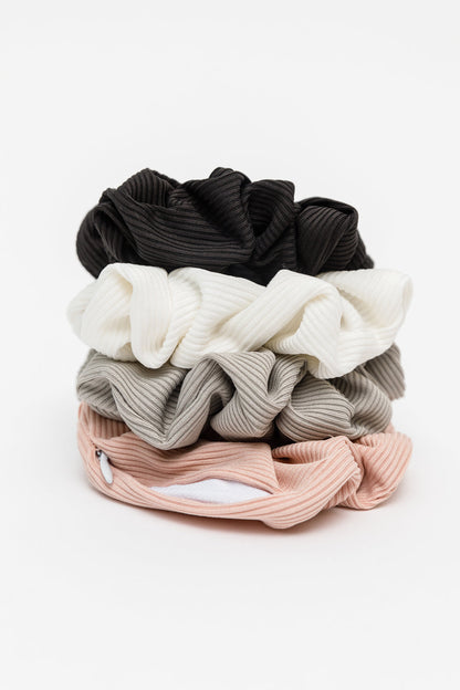 Set of four scrunchies in black, white, gray, and pink on a white background