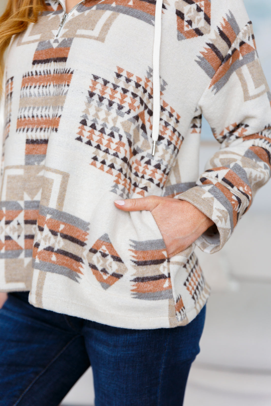 Person wearing a patterned hoodie with a blurred background