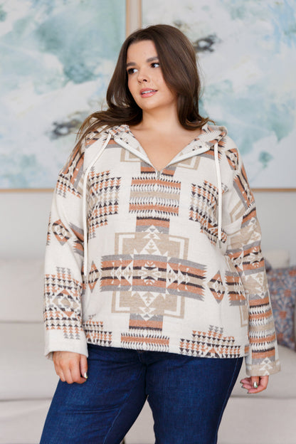 Woman wearing a patterned hoodie with a neutral background